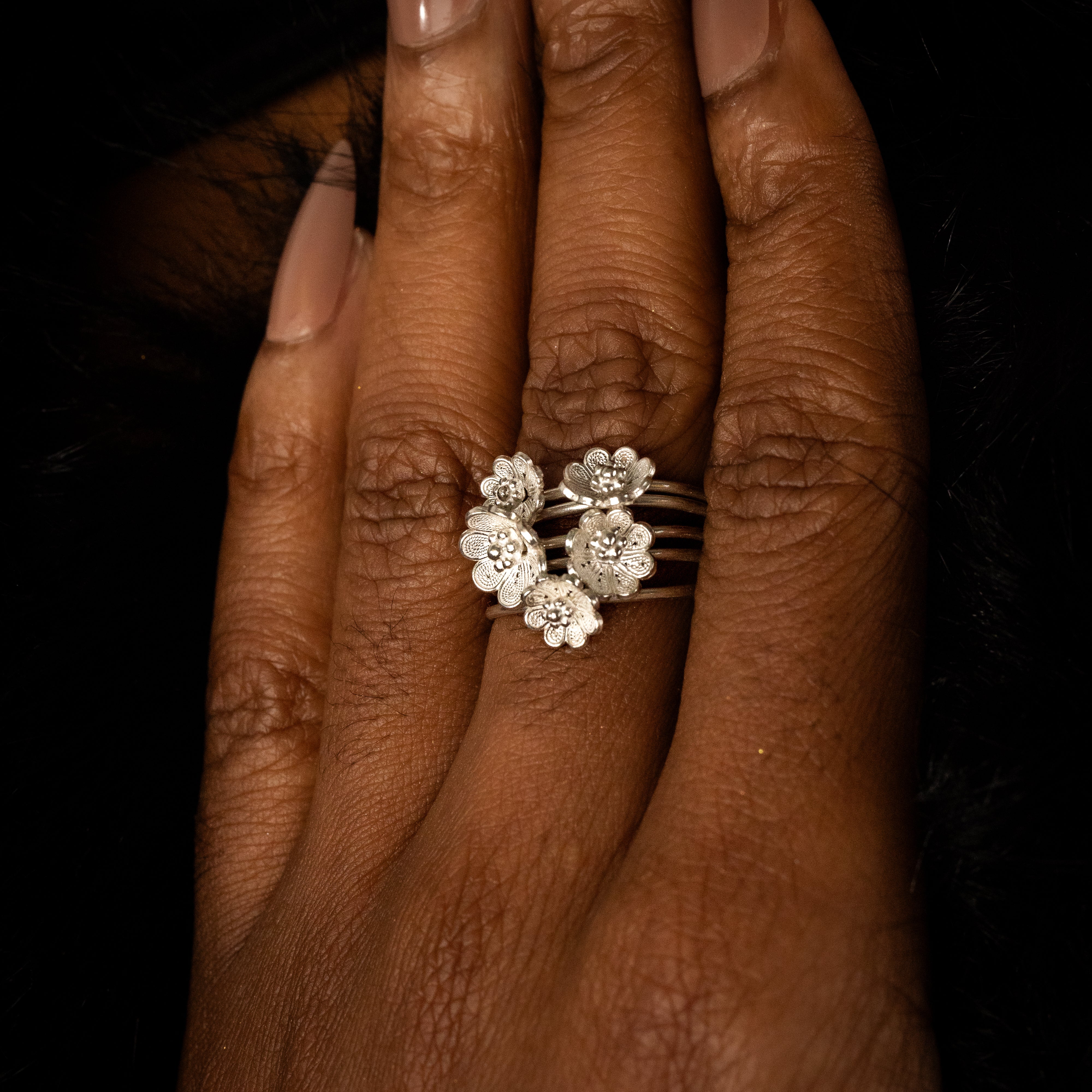 Artisan-crafted Azalea Spin Ring styled on a hand, showing off the adjustable band and masterful 999 fine silver filigree.