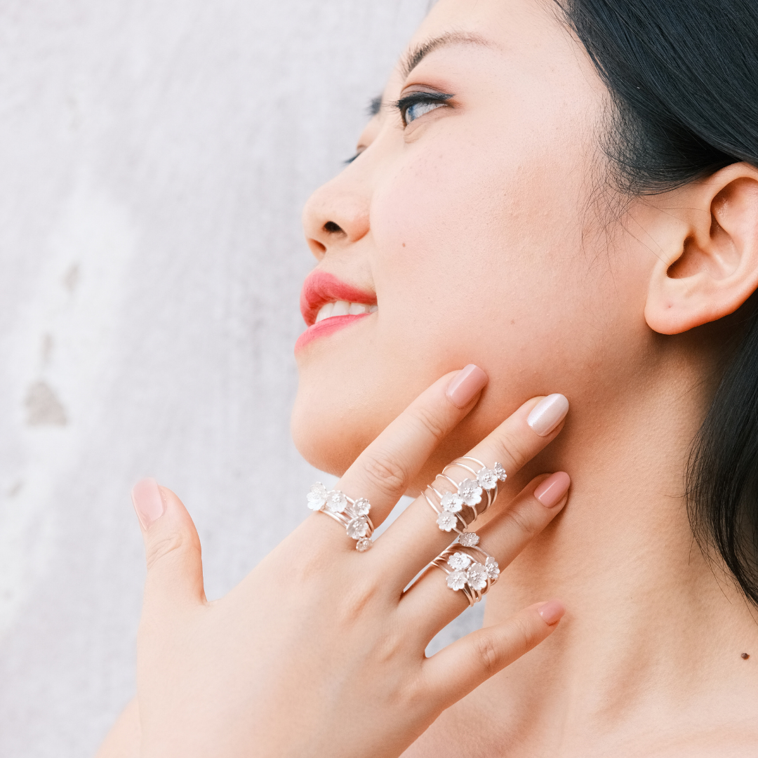 The Versatile Azalea Spin Ring styled with blossoms aligned, showcasing the high-shine 999 silver and ornamental filigree artistry.